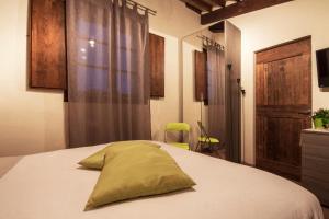 ein Schlafzimmer mit einem Bett mit einem grünen Kissen darauf in der Unterkunft Da Leo in Montefollonico