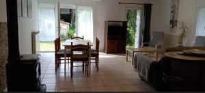 a living room with a table and chairs and a couch at Gite 2 des Ecuries du Seillery in La Clisse
