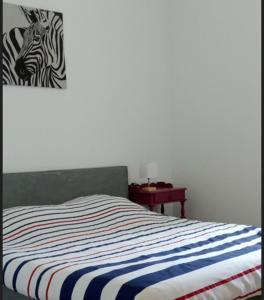 a bedroom with a bed with a zebra picture on the wall at Gite 2 des Ecuries du Seillery in La Clisse
