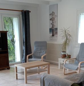 a living room with two chairs and a coffee table at Gite 2 des Ecuries du Seillery in La Clisse