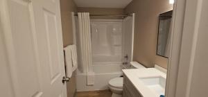 a white bathroom with a toilet and a sink at Farwest Motel in Everett