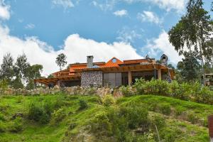 a house with an orange roof on top of a hill at Glamping mágico en el Bosque in Oicatá +11 photos