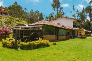 a house with a horse carriage in a yard at Glamping mágico en el Bosque in Oicatá