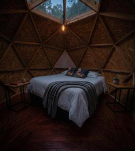 a room with a large bed in a triangular room at Glamping mágico en el Bosque in Oicatá