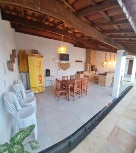 a dining room and living room with a table and chairs at Casapraiatracuá in Beberibe