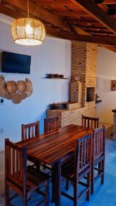 a wooden table and chairs in a room with a fireplace at Casapraiatracuá in Beberibe