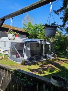 a camper parked in a yard next to a fence at Radbjerg privat camping in Væggerløse