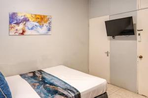 a bedroom with a bed with a painting on the wall at Mona Master suite in Kingston