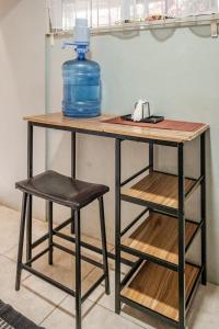 a table with two stools and a blue bottle on top at Mona Master suite in Kingston