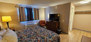 a hotel room with a bed and a flat screen tv at Farwest Motel in Everett
