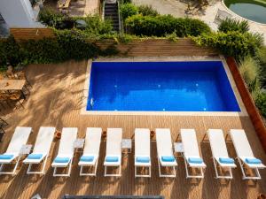 an overhead view of a swimming pool with white lounge chairs at Bodrum Blue Bay Hotel & Restaurant in Bodrum City