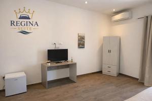 a room with a desk and a tv on a wall at Regina Suite Mazara in Mazara del Vallo