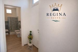 a bathroom with a regina suite sign on the wall at Regina Suite Mazara in Mazara del Vallo