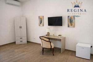 a room with a desk and a tv and a desk with a chair at Regina Suite Mazara in Mazara del Vallo +9 photos