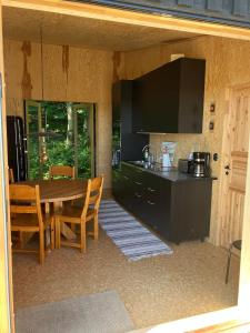 a kitchen and dining room with a table and chairs at The forest in Sjöbo