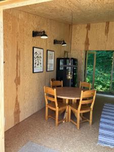 a dining room with a wooden table and chairs at The forest in Sjöbo