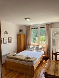 a bedroom with a large bed and a table at Adamov Konak Apartmani in Lazići
