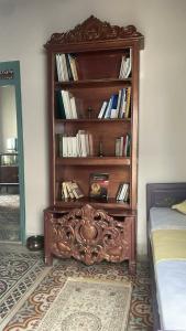 a book shelf filled with books in a bedroom at Beit Emna3 in Kairouan