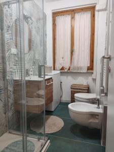 a bathroom with a toilet and a glass shower at Verde Lido in Livorno