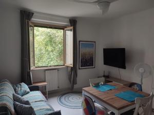 a living room with a couch and a table and a window at Verde Lido in Livorno