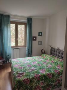 a bedroom with a large bed with a floral bedspread at Verde Lido in Livorno