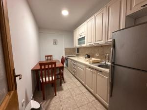 a kitchen with a table and a stainless steel refrigerator at Boulevard Mitrovica in Mitrovica +13 photos