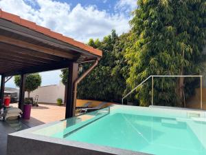 a swimming pool on a patio with a large tree at Los Jazmines in Agaete