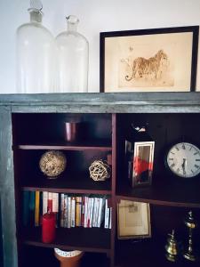 a book shelf with a clock and some books at ValTho Orelle Le Paradis Blanc in Orelle