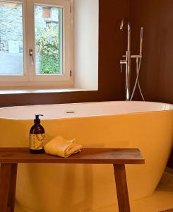 a yellow bath tub in a bathroom with a window at ValTho Orelle Le Paradis Blanc in Orelle +26 photos