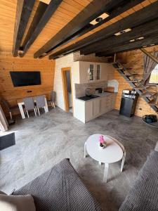 a living room with a white table and a kitchen at Brvnare na Oku Zlatibor in Ocka Gora
