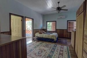 a bedroom with a bed and a ceiling fan at Charming 2BR Beach House Ideal for Extended Stays in Placencia