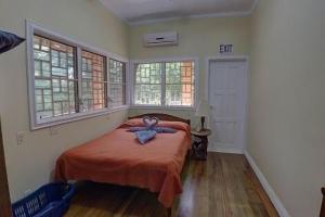 a bedroom with a bed with a blue bow on it at Charming 2BR Beach House Ideal for Extended Stays in Placencia