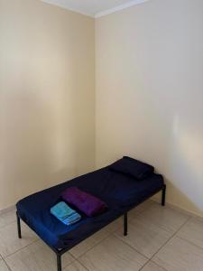a bed in a corner of a room with blue sheets at Casa próximo da Havan, UFMS e ArenaMix com Garagem in Três Lagoas