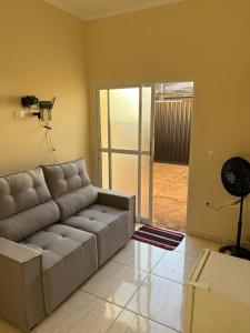 a living room with a couch and a fan at Casa próximo da Havan, UFMS e ArenaMix com Garagem in Três Lagoas