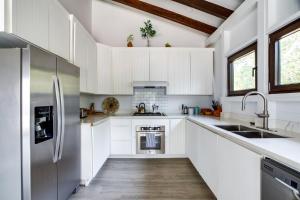 a kitchen with white cabinets and a wooden floor at Picture-Perfect 2-Bedroom Oceanfront Home w Pool in Placencia