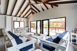 a living room with white chairs and a table at Picture-Perfect 2-Bedroom Oceanfront Home w Pool in Placencia +33 photos