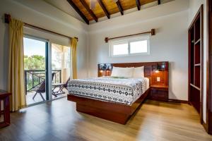 a bedroom with a bed and a balcony at Elegant Beachfront Villa Pool & Beach Family Fun in Maya Beach