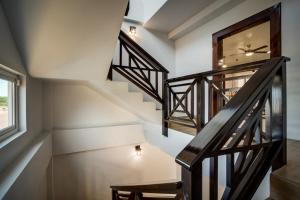 a staircase in a home with white walls and wooden railings at Elegant Beachfront Villa Pool & Beach Family Fun in Maya Beach