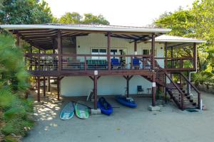 a house with a deck with surfboards on the beach at Spacious Beachfront Family Home w Caribbean Views in Maya Beach