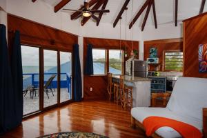 a bedroom with a bed and a kitchen with a view of the ocean at Beachfront 3-Bed, 2-Bath Family Getaway with Pool in Placencia