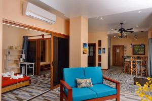 a living room with a blue chair and a bed at Beachfront 3-Bed, 2-Bath Family Getaway with Pool in Placencia