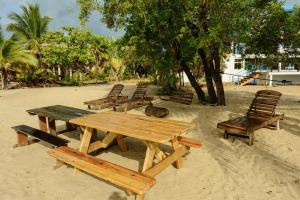 a group of picnic tables and chairs on the beach at Beachfront 3-Bed, 2-Bath Family Getaway with Pool in Placencia +67 photos