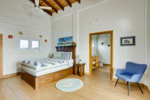 a bedroom with a bed and a blue chair at Grand Sunset Decks Luxury Home on the Lagoon in Maya Beach