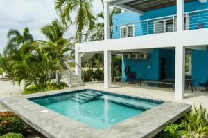 a villa with a swimming pool in front of a house at Grand Sunset Decks Luxury Home on the Lagoon in Maya Beach