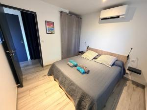 a bedroom with a bed with two towels on it at Chez Fred et Marie in Figari