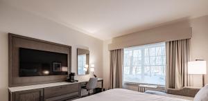 a hotel room with a bed and a large window at Hotel Bridgton in Bridgton