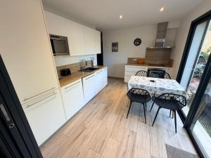 a kitchen with a table and chairs and a kitchen with white cabinets at Chez Fred et Marie in Figari