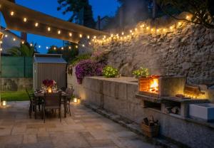 a patio with a fireplace and a table with lights at Casa Baixo O Castelo in Puente Caldelas