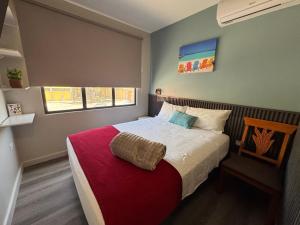 ein Schlafzimmer mit einem großen Bett und einer roten Decke in der Unterkunft Central Boutique Hotel in Oranjestad + 57 Fotos