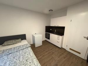 a small room with a bed and a kitchen at Cozy Room Echterdingen Stuttgart Airport & Messe in Leinfelden-Echterdingen